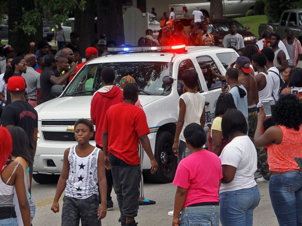 PHOTO: Protesters bang on the side of a police car, Aug. 10, 2014, in Ferguson, Mo.