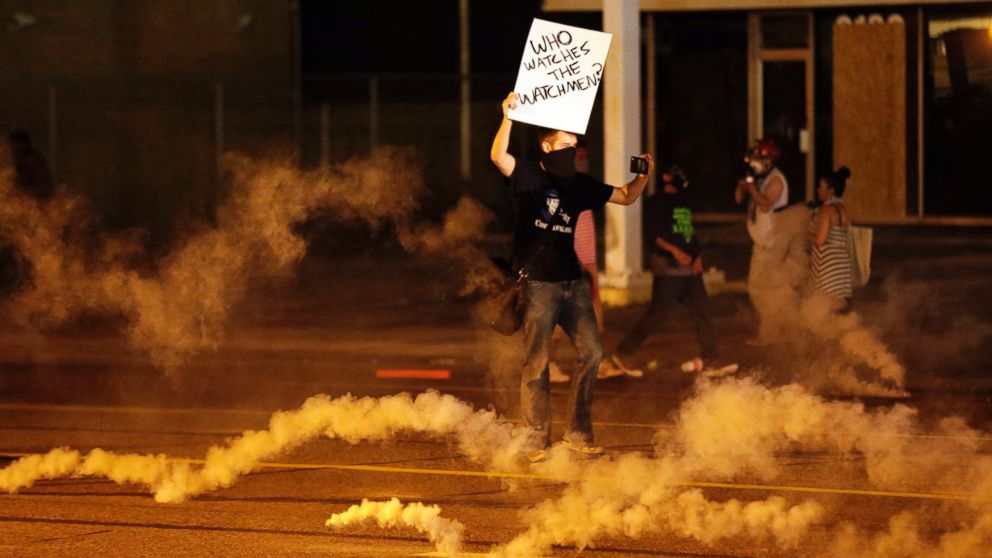 PHOTO: A protester stands in the street after police fired tear gas to disperse a crowd in Ferguson, Mo., Aug. 17, 2014.