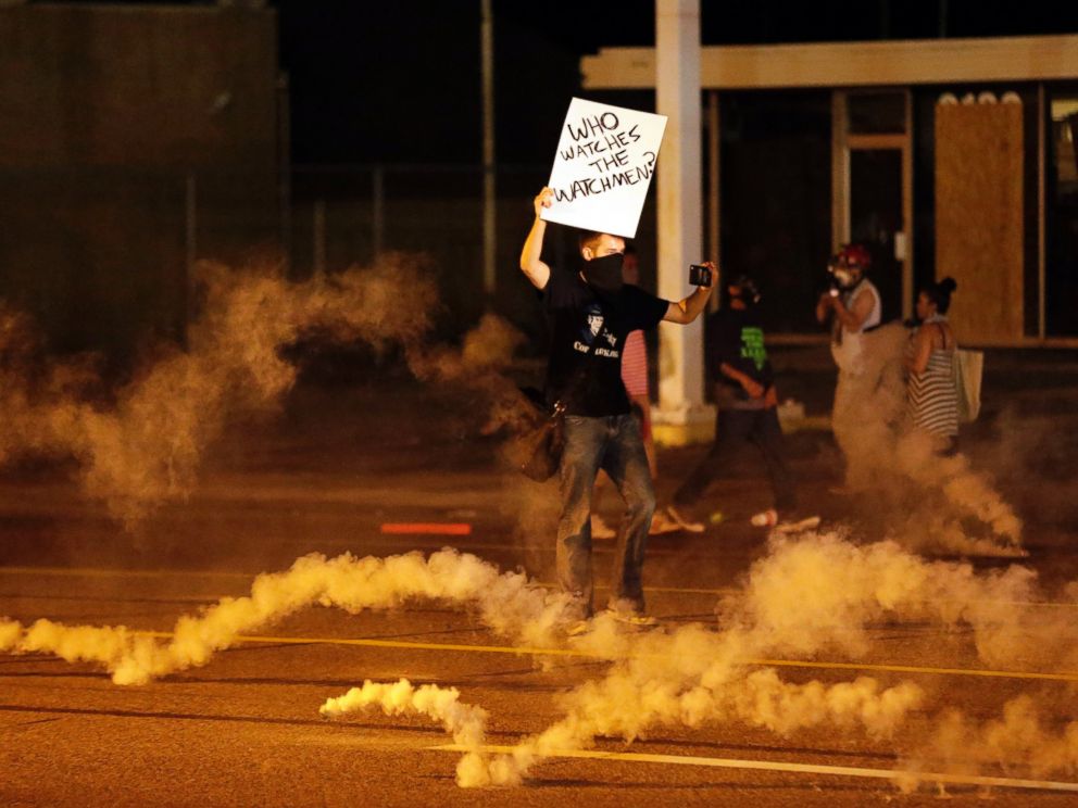 PHOTO: A protester stands in the street after police fired tear gas to disperse a crowd in Ferguson, Mo., Aug. 17, 2014.