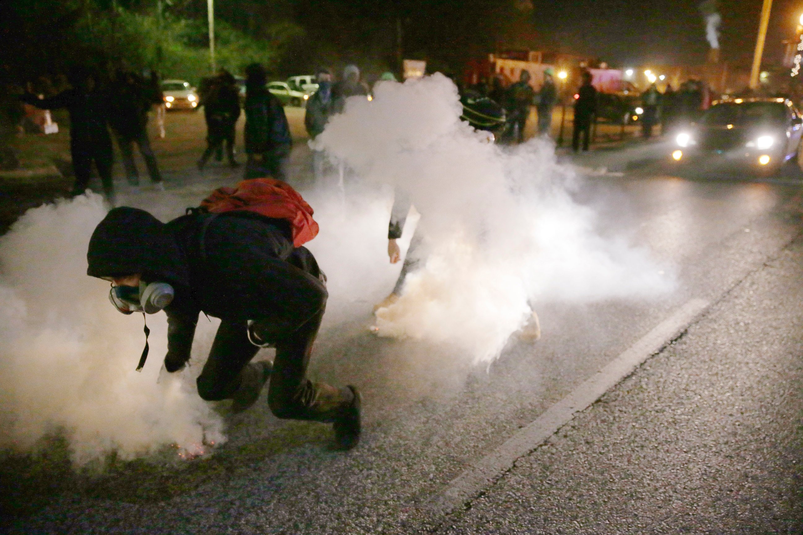 PHOTO: Protesters grab smoke canisters and throw them to police, Nov. 25, 2014, in Ferguson, Mo.