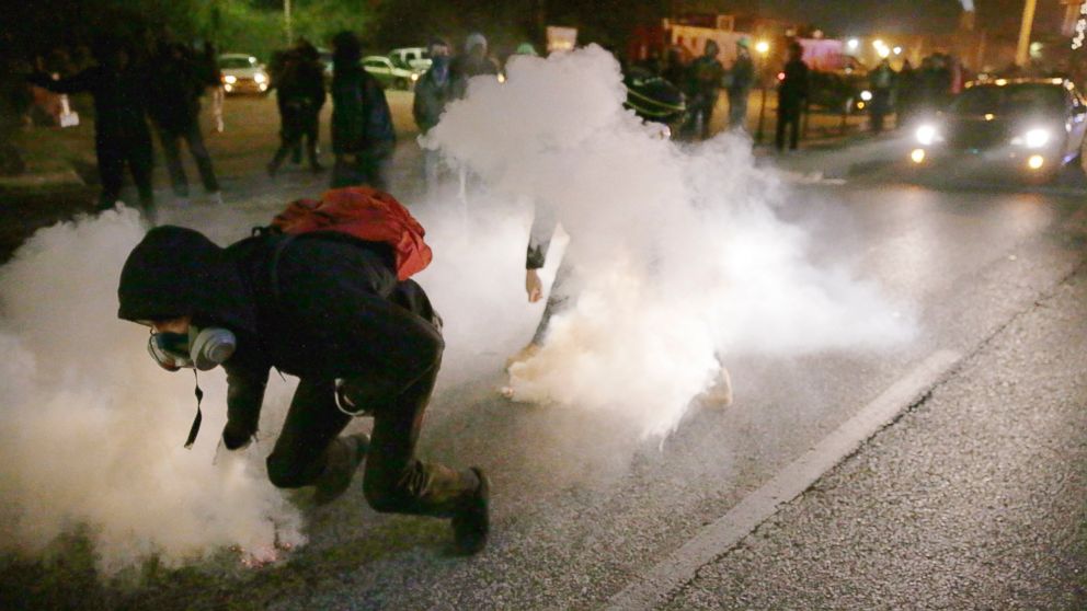 PHOTO: Protesters grab smoke canisters and throw them to police, Nov. 25, 2014, in Ferguson, Mo.