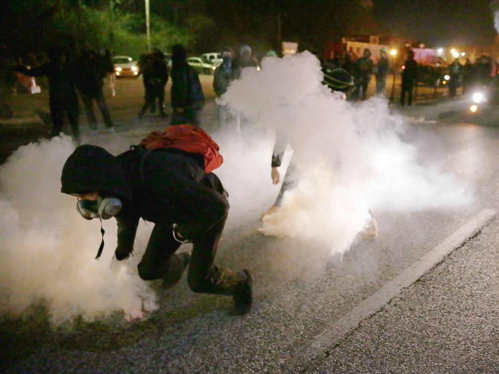 PHOTO: Protesters grab smoke canisters and throw them to police, Nov. 25, 2014, in Ferguson, Mo.
