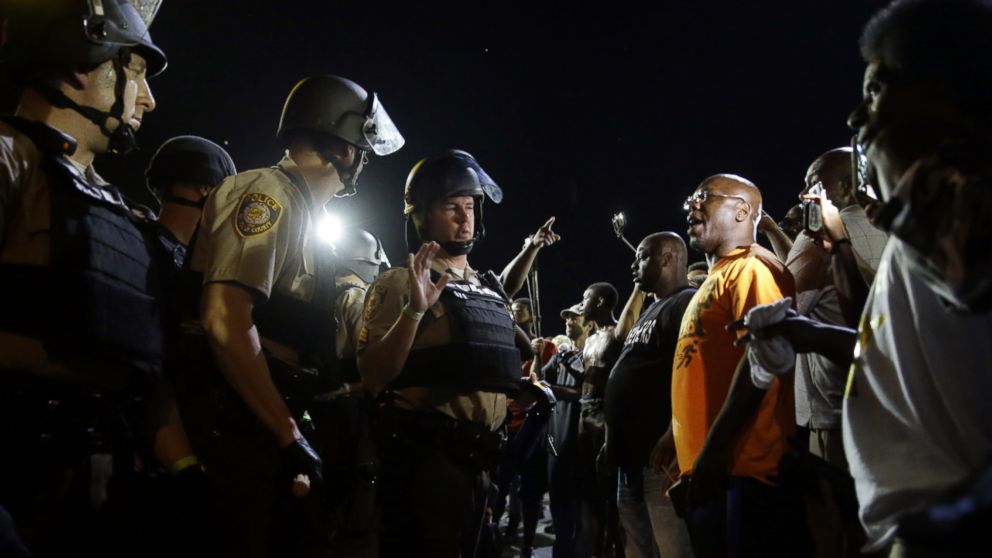 Officers and protesters face off along West Florissant Avenue, Aug. 10, 2015, in Ferguson, Mo.