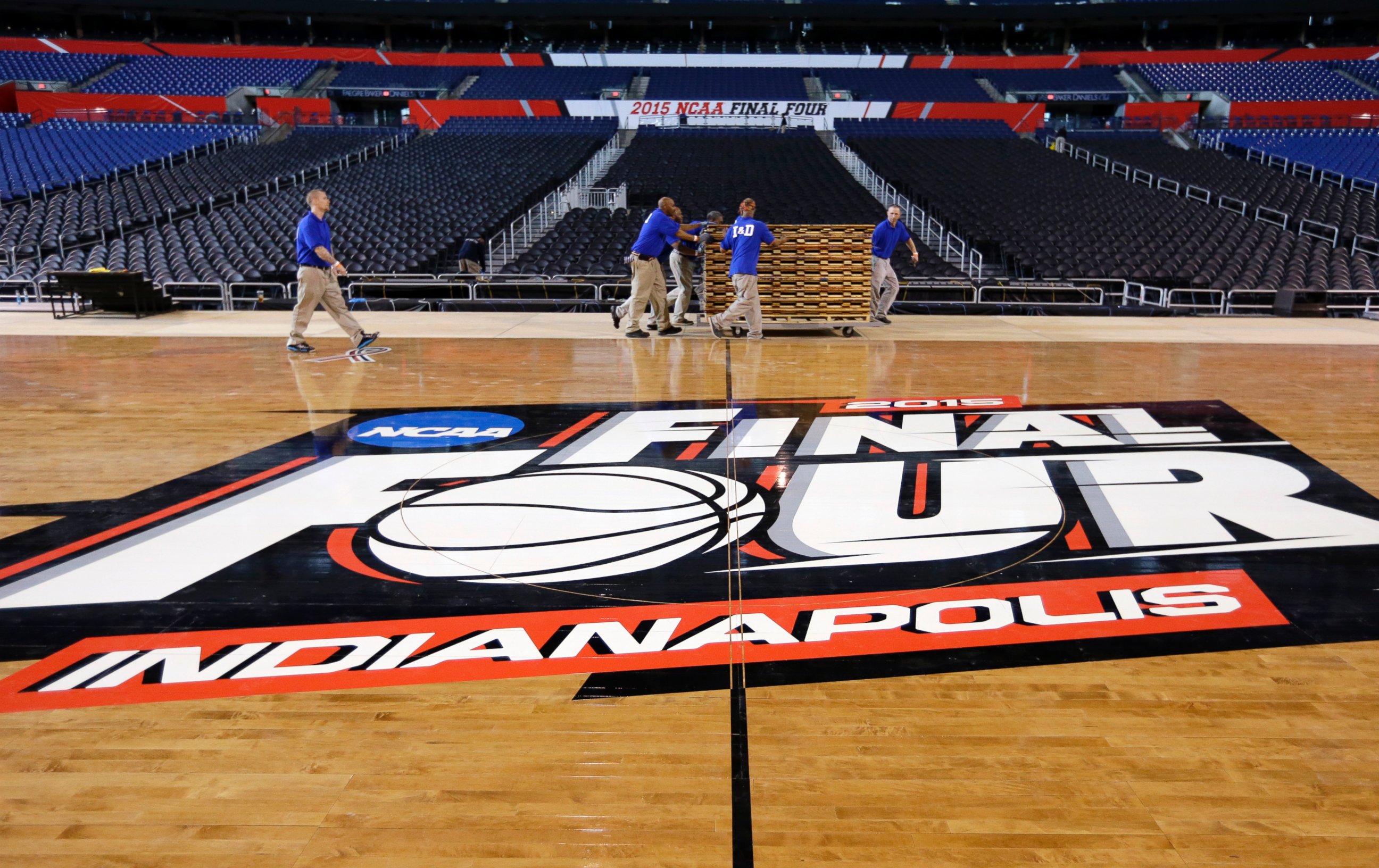 PHOTO: Workers at Lucas Oil Stadium install the court in Indianapolis, March 27, 2015.