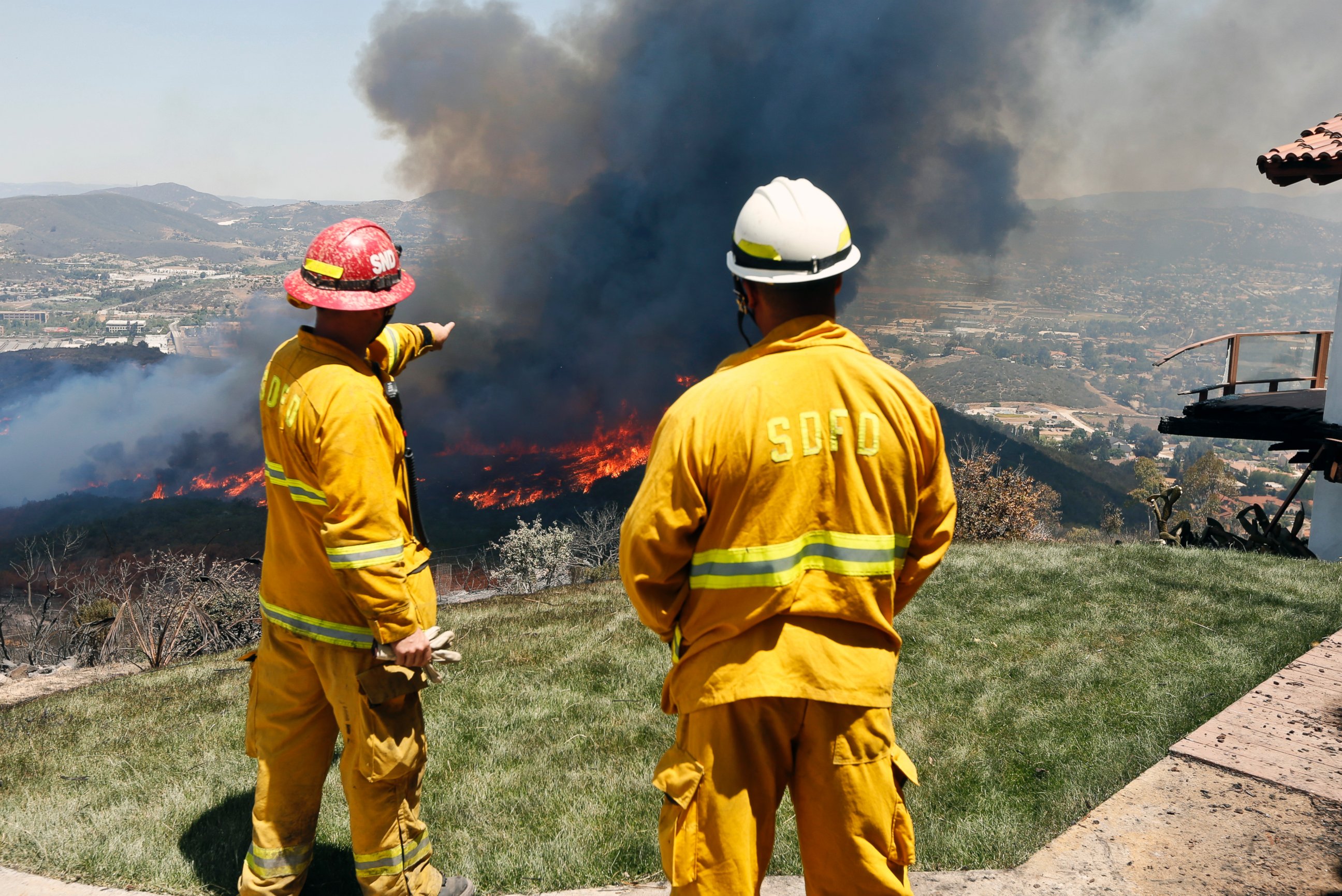 PHOTO: Firefighters plan their attack as the brush fire flares up heading toward homes, May 15, 2014, in San Marcos, Calif.