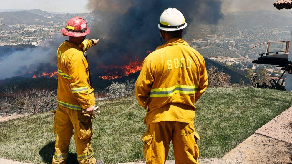 PHOTO: Firefighters plan their attack as the brush fire flares up heading toward homes, May 15, 2014, in San Marcos, Calif.