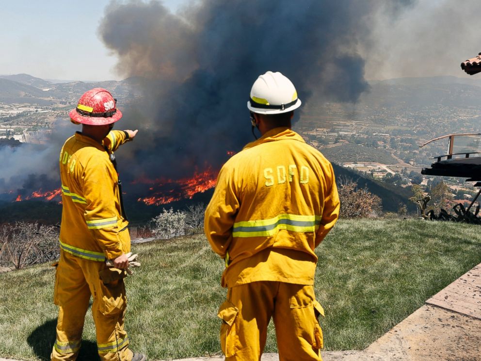 PHOTO: Firefighters plan their attack as the brush fire flares up heading toward homes, May 15, 2014, in San Marcos, Calif.