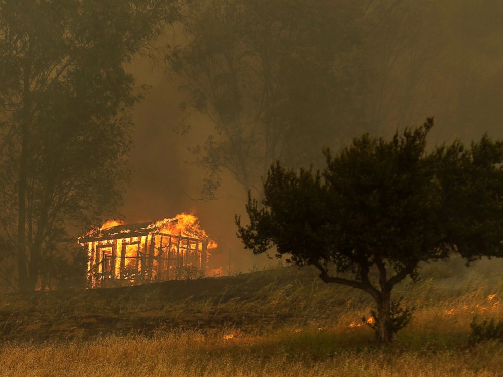 PHOTO: Fire engulfs a structure during a wildfire, May 15, 2014, in Escondido, Calif.
