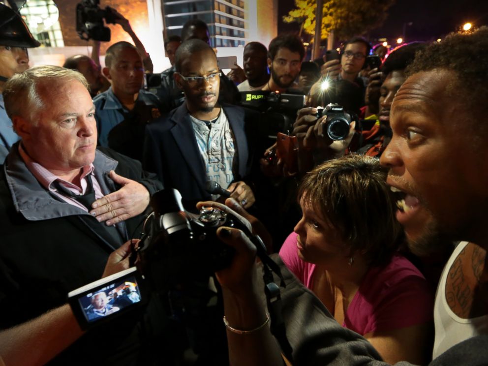 Ferguson Police Chief Tom Jackson, left, speaks before protesters in front of the Ferguson Police Department, on Thursday, Sept. 25, 2014.
