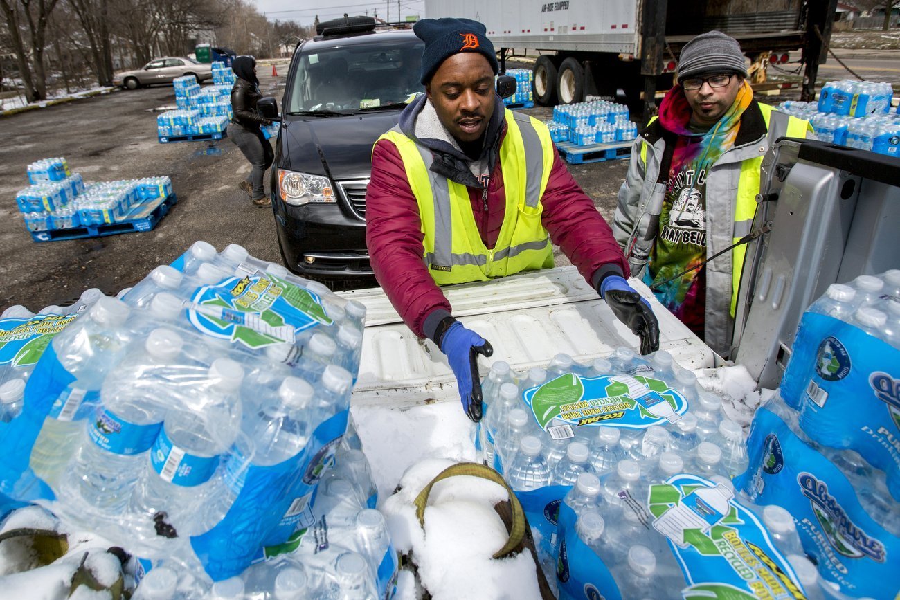 PHOTO: Water distribution employee Albrey Kirkland places water cases into the back of a pickup at a water distribution center on North Franklin Avenue, April 5, 2018 in Flint, Mich. 