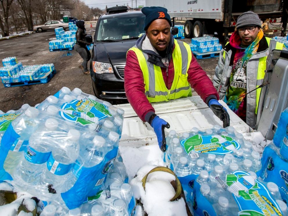 PHOTO: Water distribution employee Albrey Kirkland places water cases into the back of a pickup at a water distribution center on North Franklin Avenue, April 5, 2018 in Flint, Mich.
