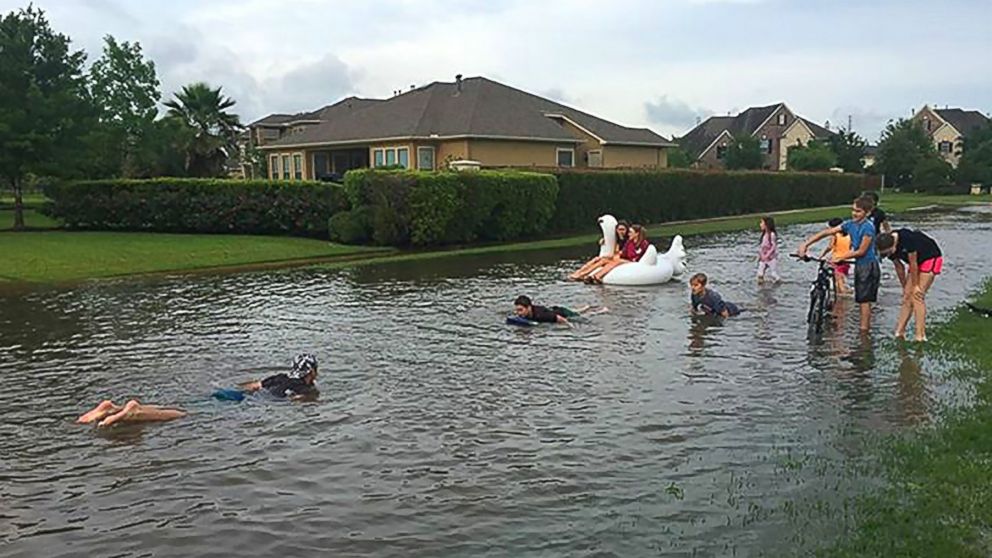 PHOTO: Children play in flood waters in the Kelliwood Park neighborhood of Katy, Texas, April 18, 2016. Flooding in and around Houston has killed at least five people and prompted mass rescues, reports said. 