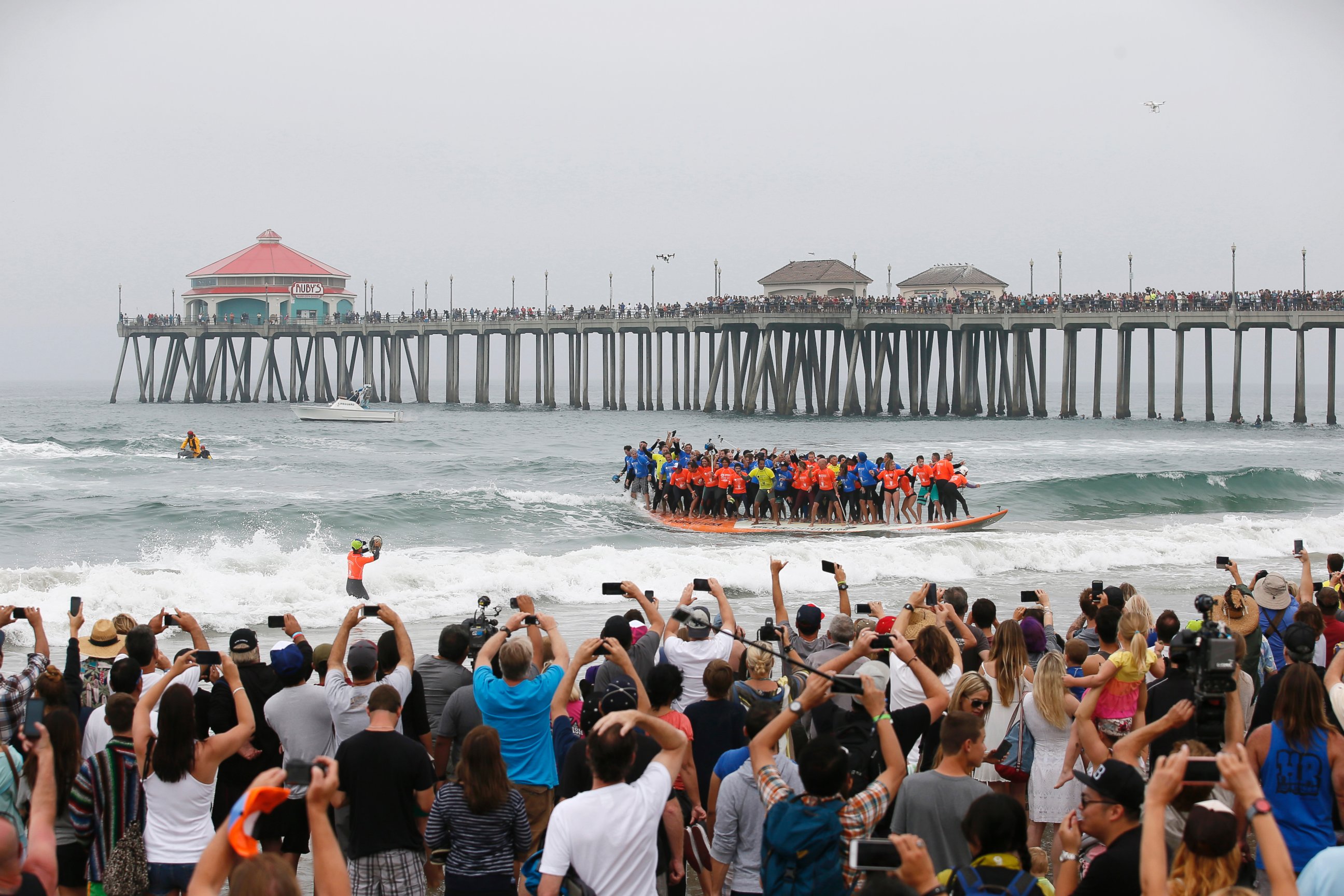 PHOTO:  Sixty-six surfers from around the world ride a custom built 42-foot, 1300 pound surfboard for 12 seconds to break the GUINNESS WORLD RECORDS® for "Most People Riding a Surfboard at Once" on Saturday, June 20, 2015 in Huntington Beach, CA.