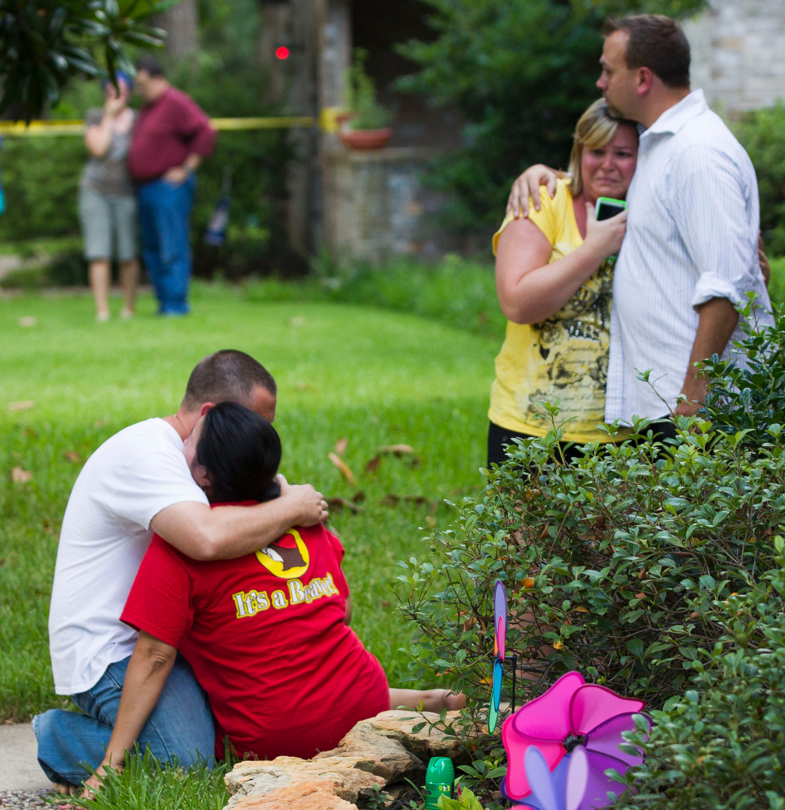 PHOTO: Neighbors embrace each other following a shooting, July 9, 2014, in Spring, Texas.