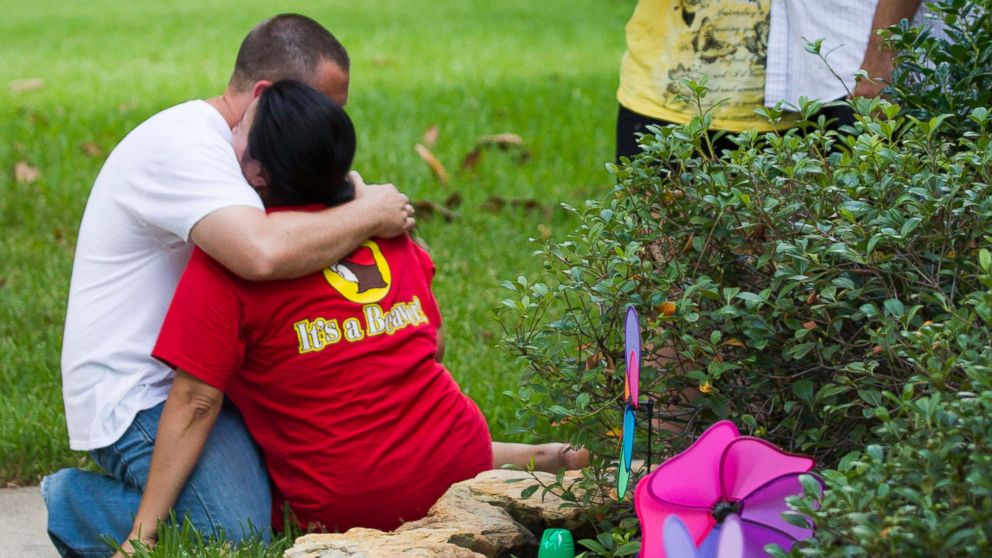 PHOTO: Neighbors embrace each other following a shooting, July 9, 2014, in Spring, Texas.