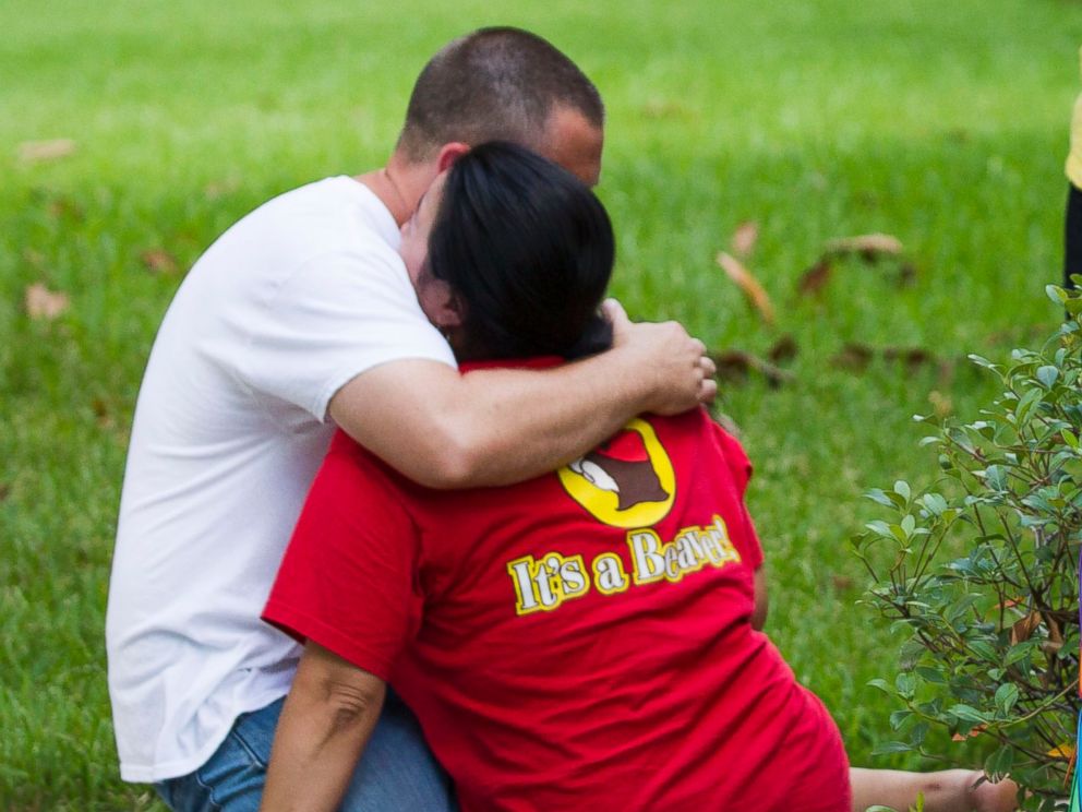 PHOTO: Neighbors embrace each other following a shooting, July 9, 2014, in Spring, Texas.
