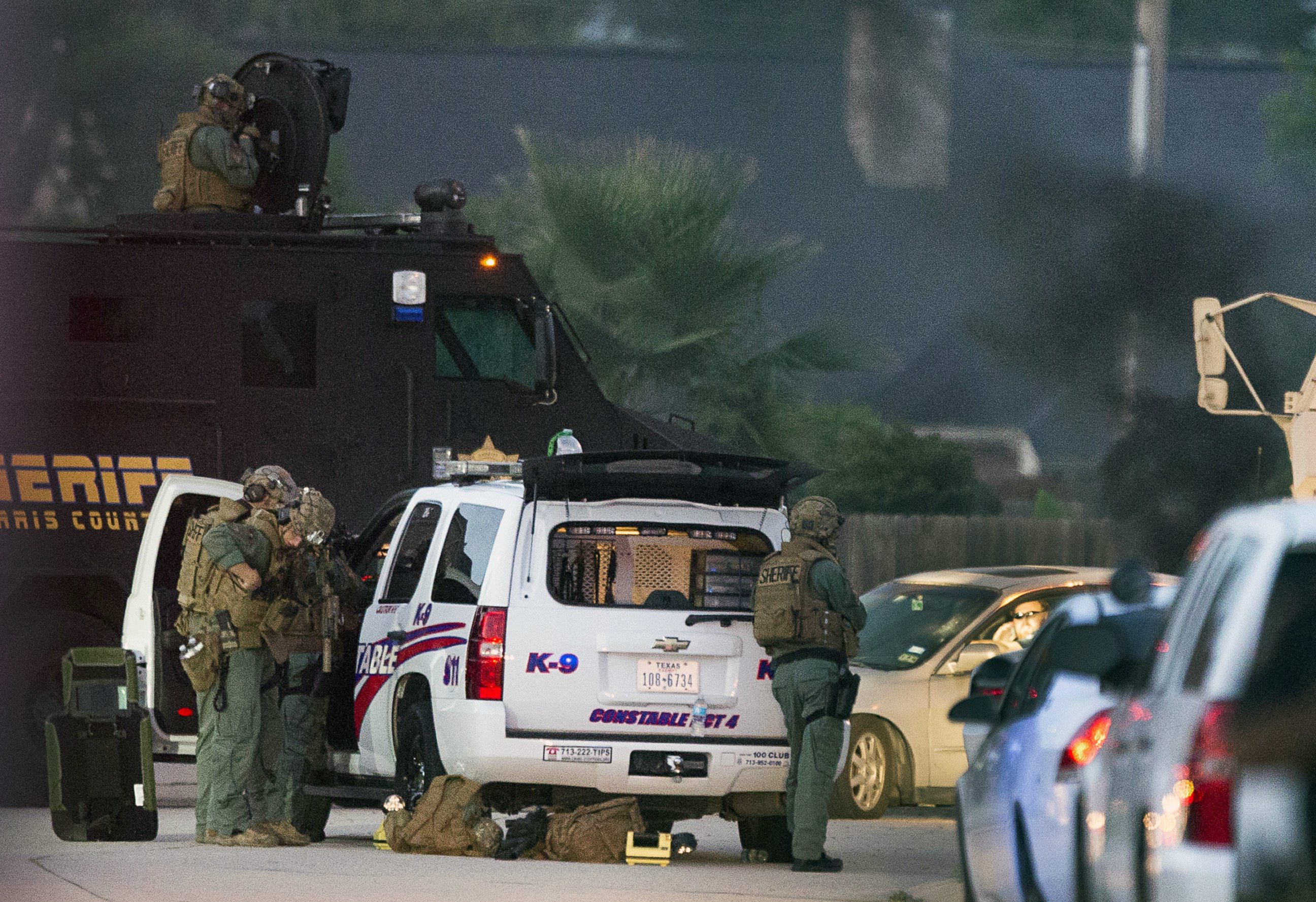 PHOTO: Law enforcement officers surround a shooting suspect in his car, July 9, 2014, in Spring, Texas.