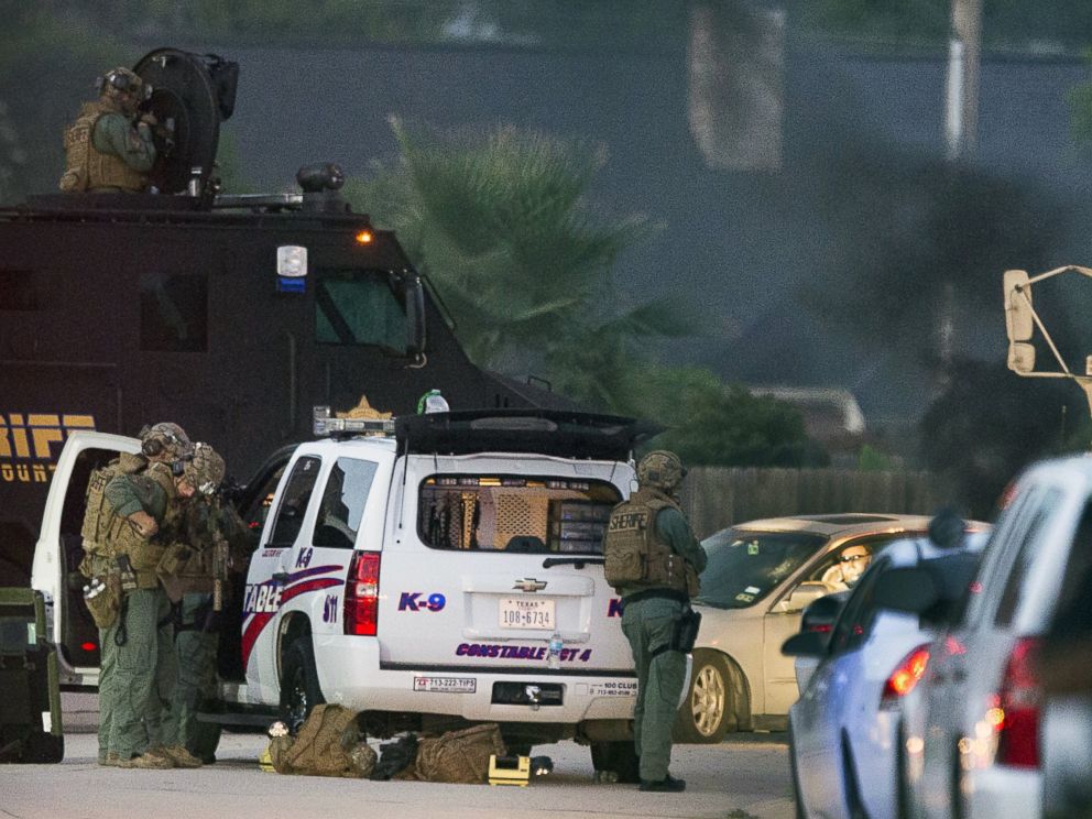 PHOTO: Law enforcement officers surround a shooting suspect in his car, July 9, 2014, in Spring, Texas.