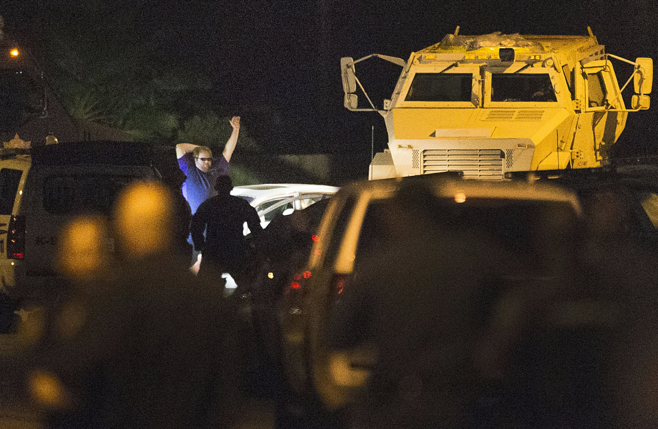 PHOTO: A shooting suspect raises his hands as law enforcement officers surround him following a three-hour standoff, July 9, 2014, in Spring, Texas.