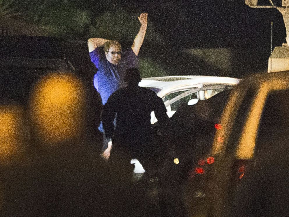 PHOTO: A shooting suspect raises his hands as law enforcement officers surround him following a three-hour standoff, July 9, 2014, in Spring, Texas.