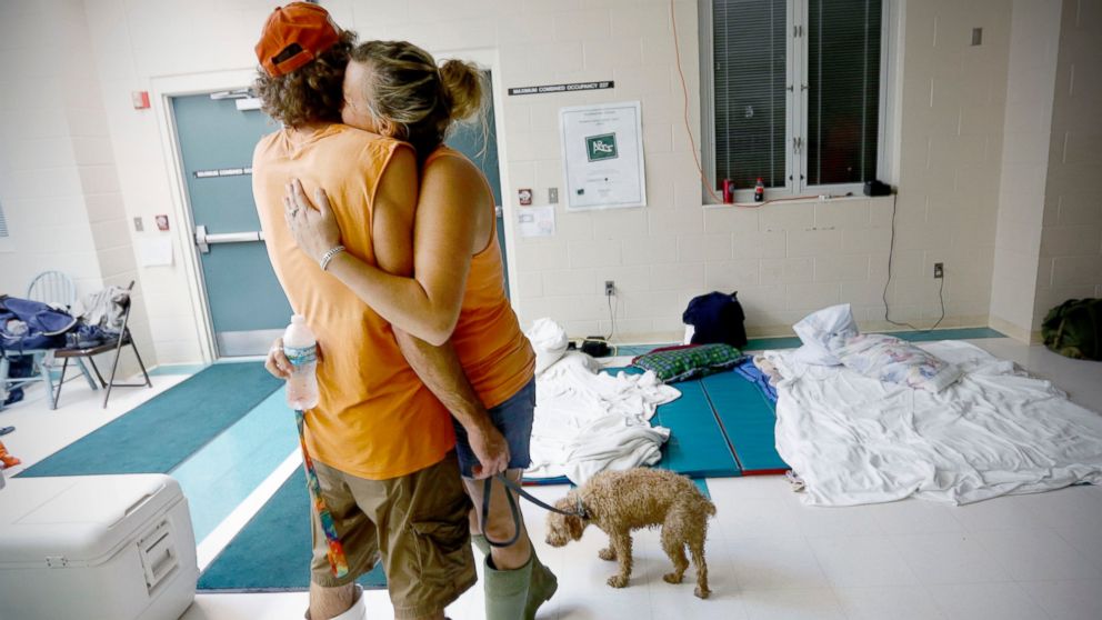 PHOTO: Chris Hacker, left, hugs his girlfriend Lyn Charlton after the couple arrived at an elementary school with their dog, Sept. 2, 2016, in Steinhatchee, Florida.