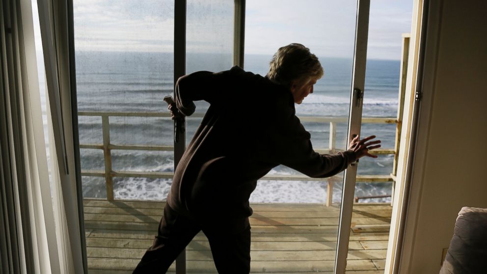 PHOTO: Eileen Horan shuts the door to her patio overlooking the Pacific Ocean after being forced to evacuate her apartment on Jan. 25, 2016, in Pacifica, Calif.