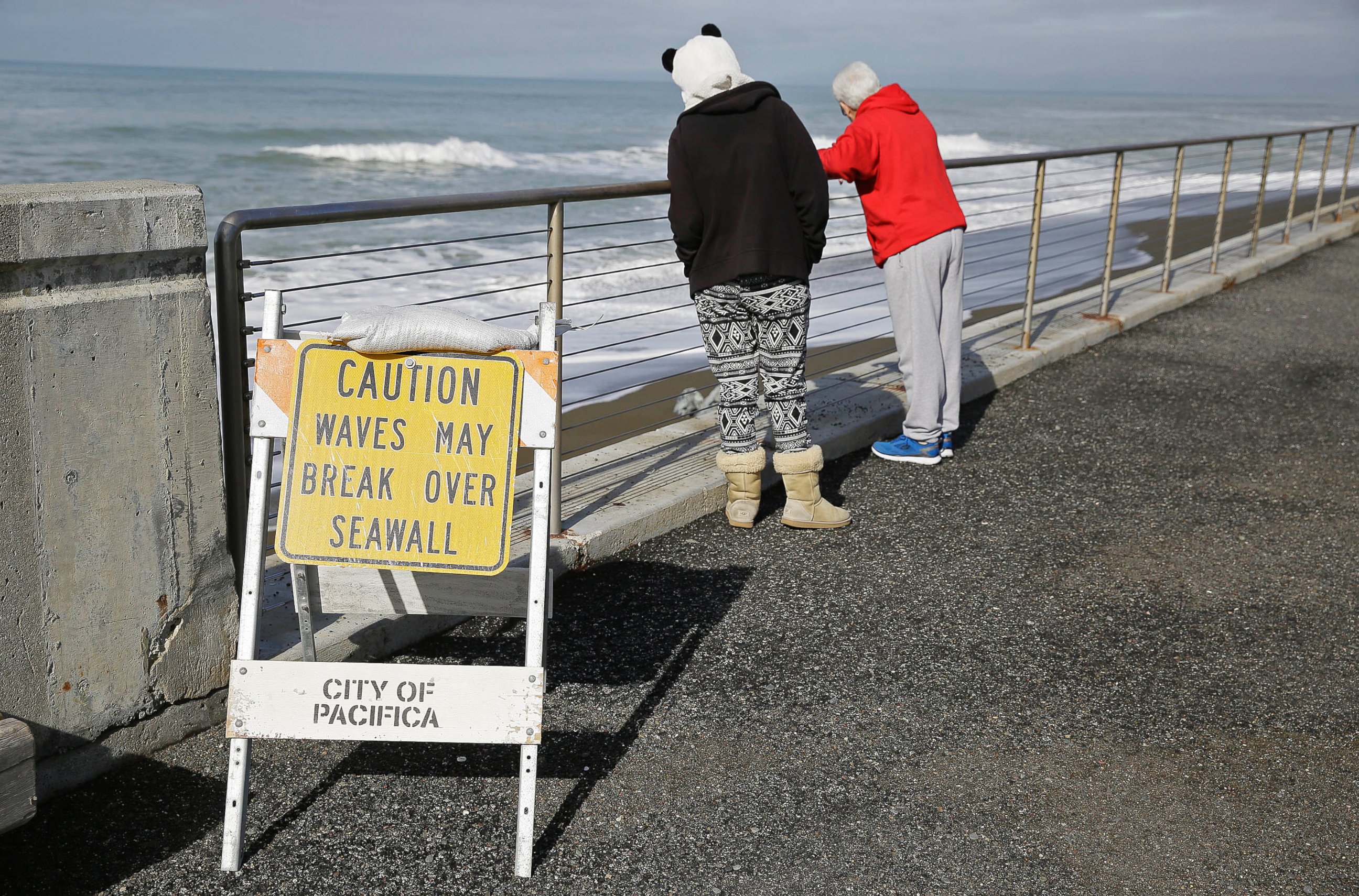 PHOTO: A couple looks at waves breaking near the seawall, Jan. 25, 2016, in Pacifica, Calif.  Strong waves caused by El Nino storms ate away part of the sea wall in the coastal community, threatening homes and an apartment building.