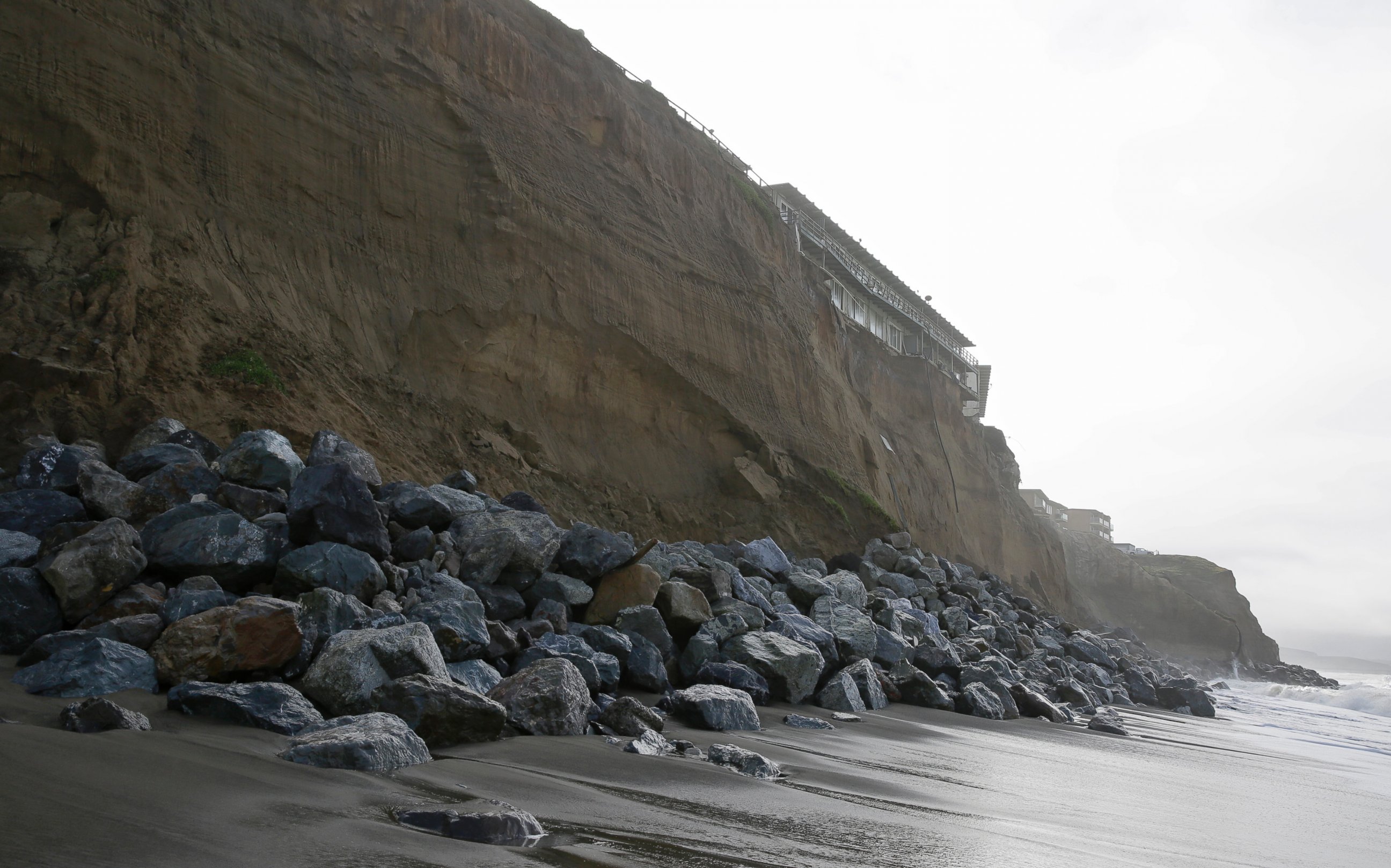 PHOTO: Boulders shore up an eroding cliff below an apartment complex, Jan. 25, 2016, in Pacifica, Calif. Strong waves caused by El Nino storms ate away part of a sea wall and cliffs threatening several homes and an apartment building.