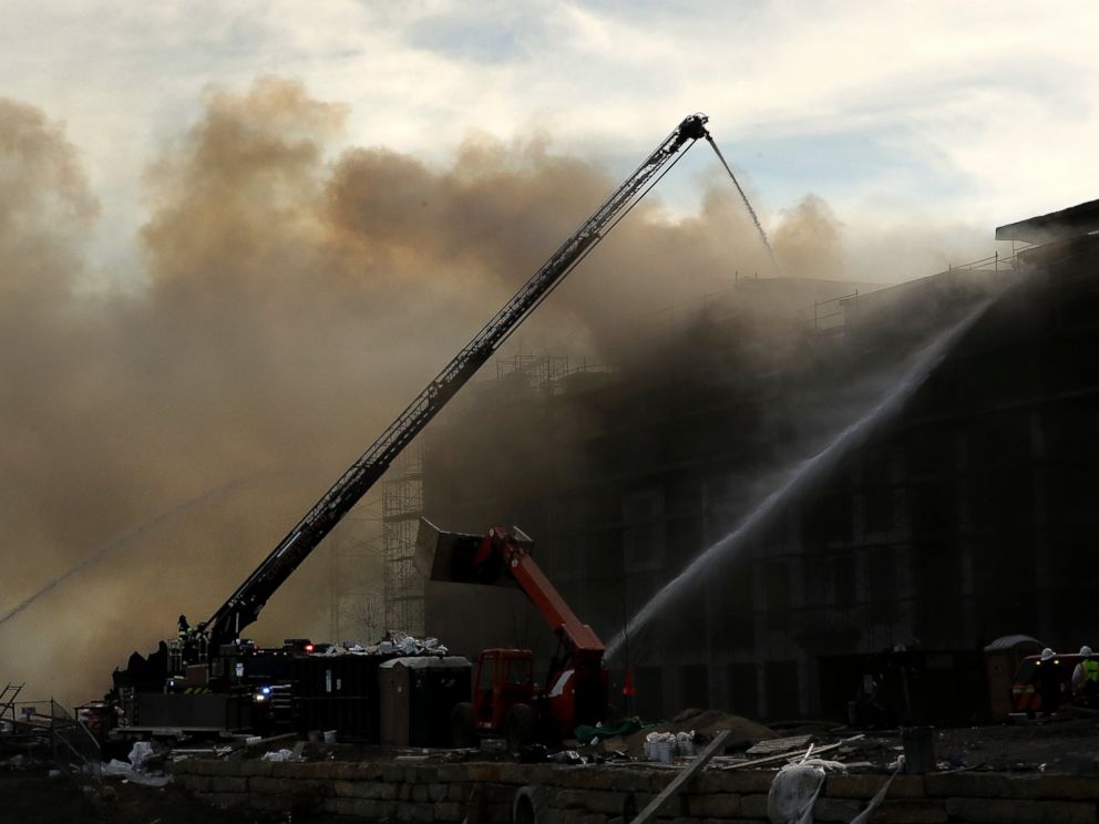 PHOTO: Firefighters fight an eight-alarm fire that began at an apartment complex under construction and than spread to several nearby homes Monday.