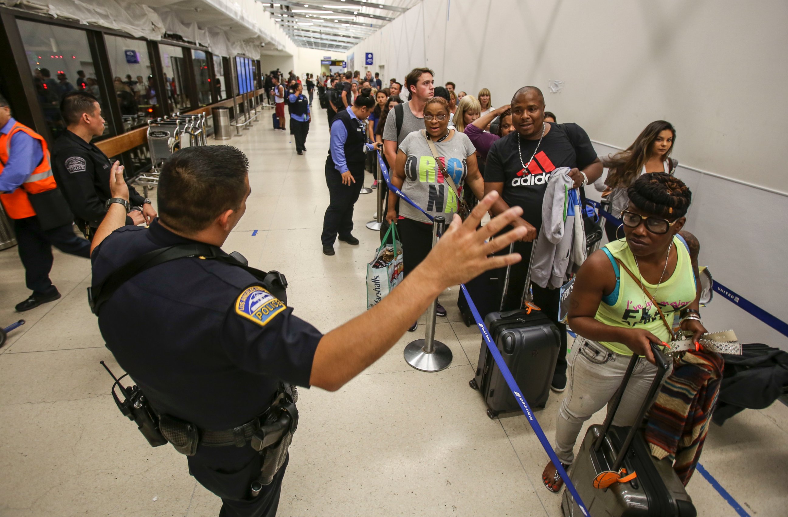 PHOTO: Police officers stand guard as passengers wait in line at Terminal 7 in Los Angeles International Airport, Sunday, Aug. 28, 2016.