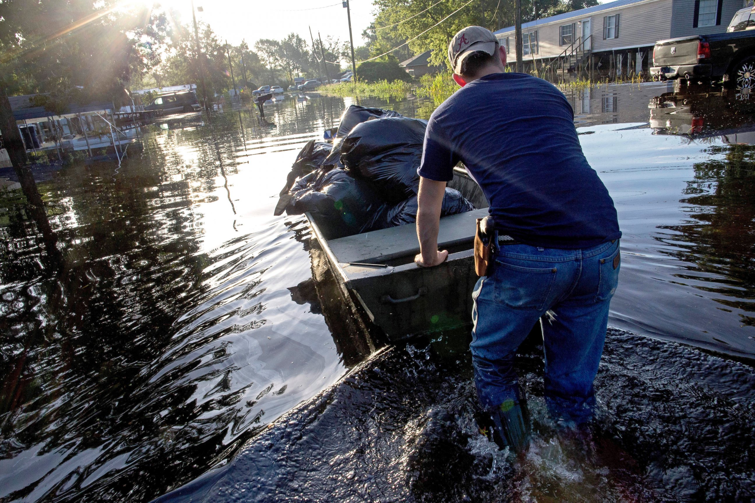PHOTO: Daniel Stover, 17, moves a boat of personal belongings from a flooded friend's home, Aug. 20, 2016, in Sorrento, Louisiana.