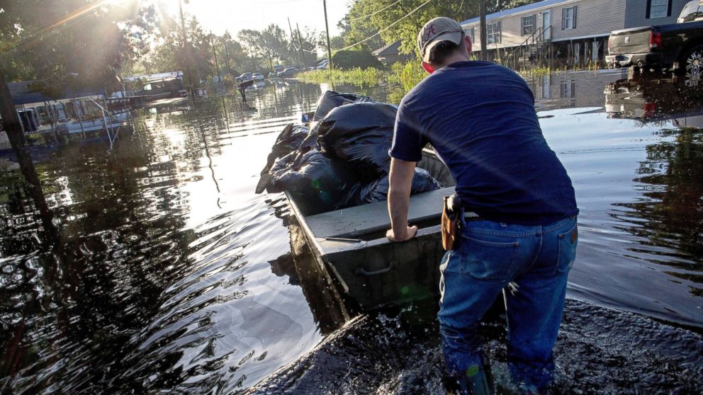 PHOTO: Daniel Stover, 17, moves a boat of personal belongings from a flooded friend's home, Aug. 20, 2016, in Sorrento, Louisiana.