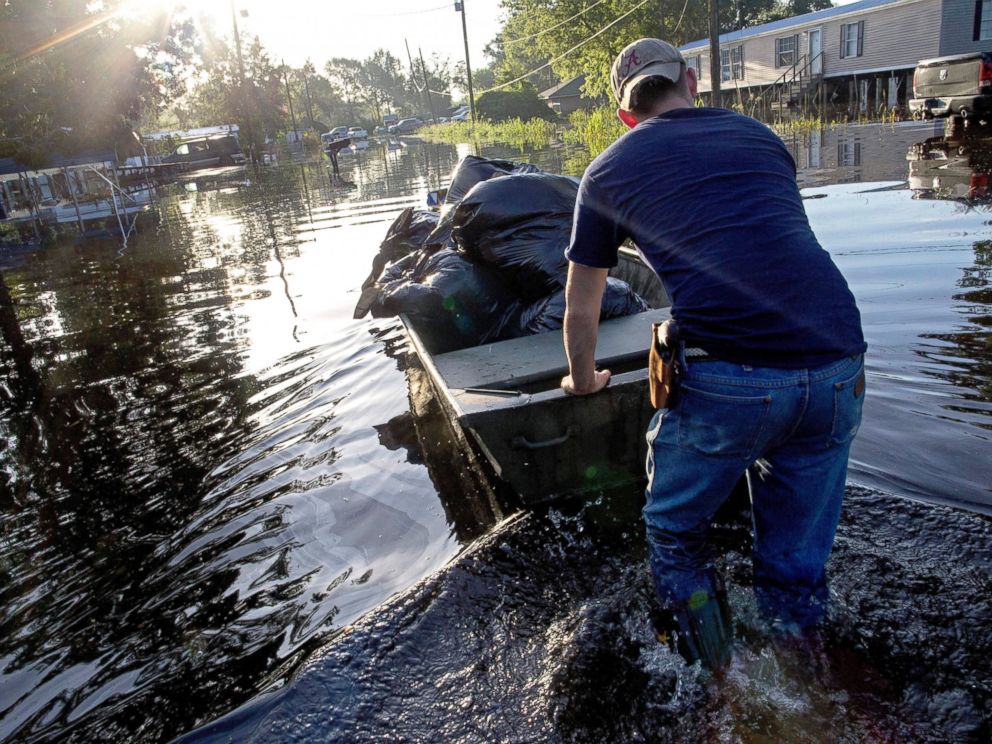 PHOTO: Daniel Stover, 17, moves a boat of personal belongings from a flooded friends home, Aug. 20, 2016, in Sorrento, Louisiana.