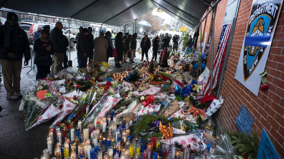 Candles and other items left by visitors make up a growing makeshift memorial, Dec. 23, 2014, near the site where New York Police Department officers Rafael Ramos and Wenjian Liu were slain in the Brooklyn borough of New York.