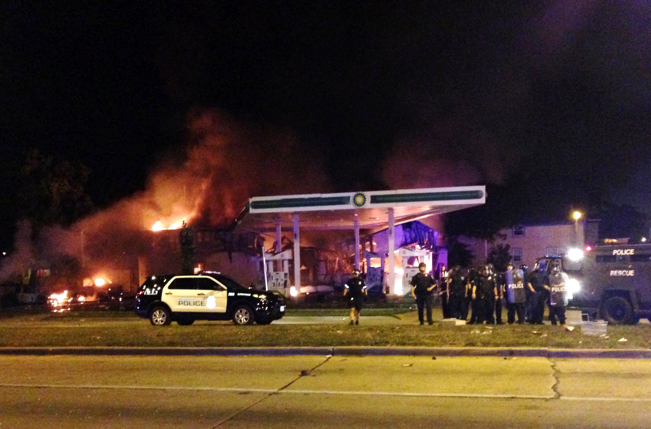 PHOTO: Authorities respond near a burning gas station as dozens of people protest following the fatal shooting of a man in Milwaukee, Saturday, Aug. 13, 2016.