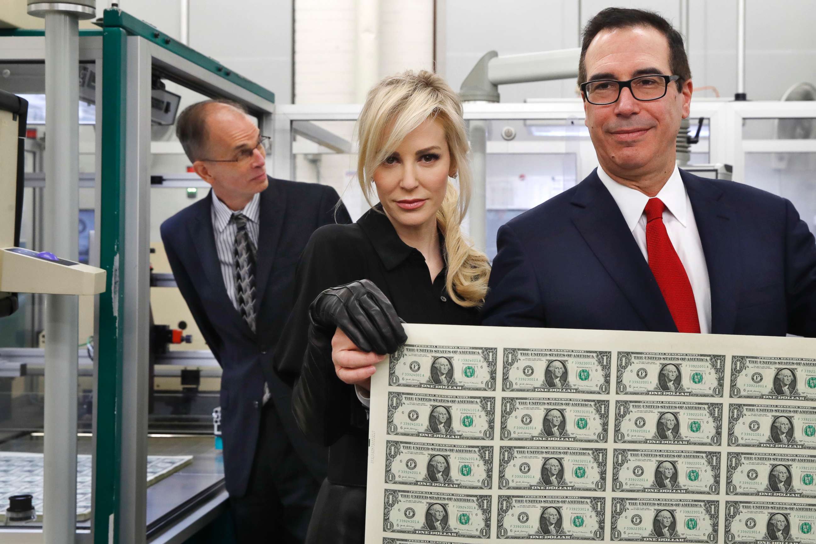 Treasury Secretary Steven Mnuchin, right, and his wife Louise Linton, hold up a sheet of new $1 bills, the first currency notes bearing his and U.S. Treasurer Jovita Carranza's signatures, Wednesday, Nov. 15, 2017.