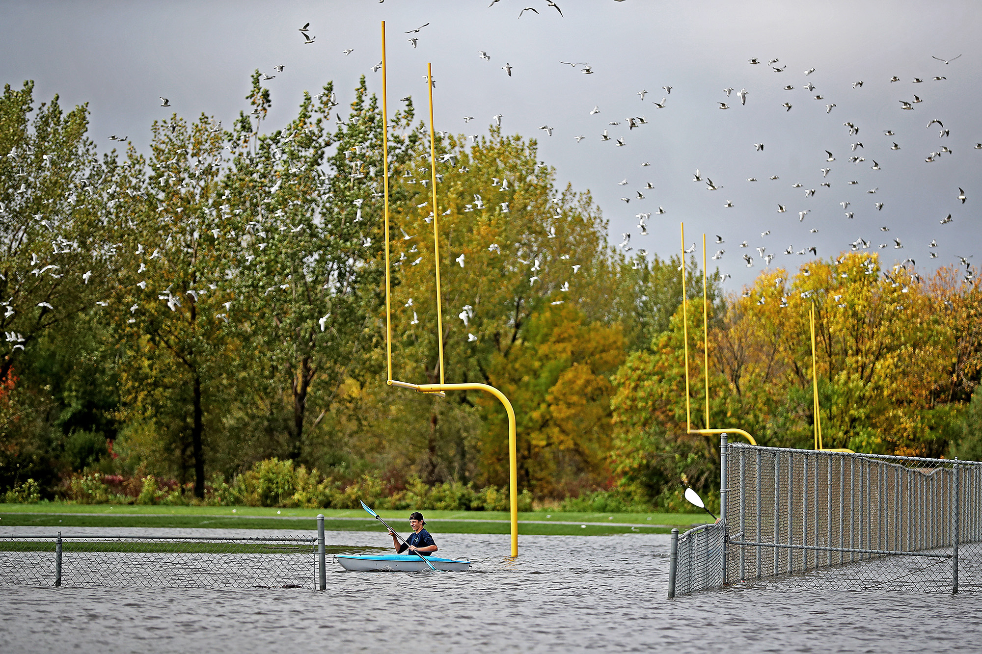 PHOTO: Justin Sampson, a member of the Waseca High School football team checks out the flooding on the football field from a kayak near the Waseca High School, Sept.  22, 2016, in Waseca, Minnesota.
