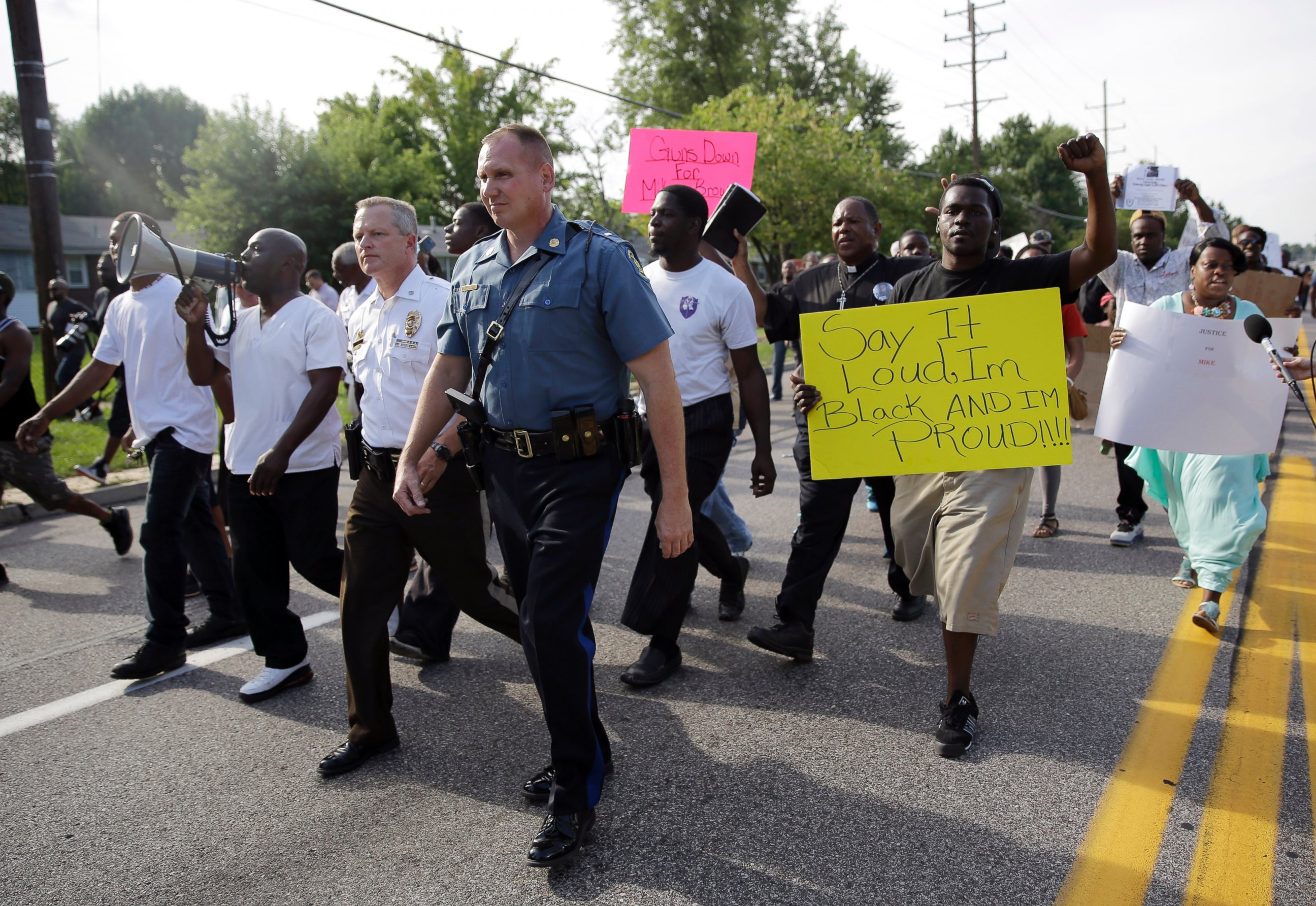 PHOTO: Thousands of demonstrators peacefully march down a street with members of the St. Louis County Police and Missouri Highway Patrol Thursday, Aug. 14, 2014, in Ferguson, Mo. 