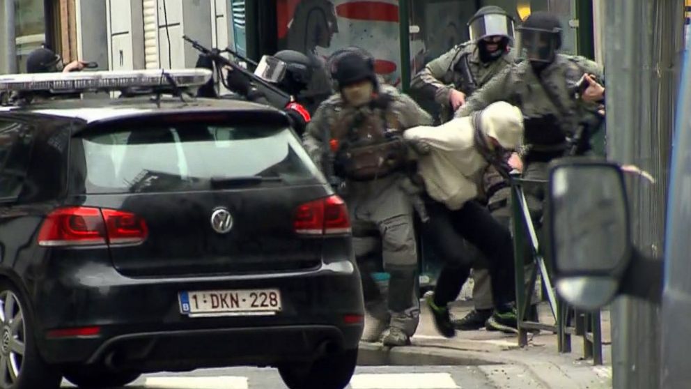 PHOTO: Armed police officers carry a suspect to a police vehicle during a raid in the Molenbeek neighborhood of Brussels, Belgium, March 18, 2016.