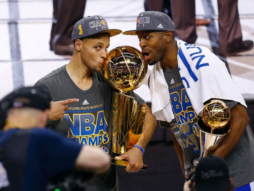 PHOTO: Golden State Warriors guard Stephen Curry, left, holds the championship trophy and Andre Iguodala holds the series MVP trophy as they celebrate winning the NBA Finals against the Cleveland Cavaliers in Cleveland, June 17, 2015.