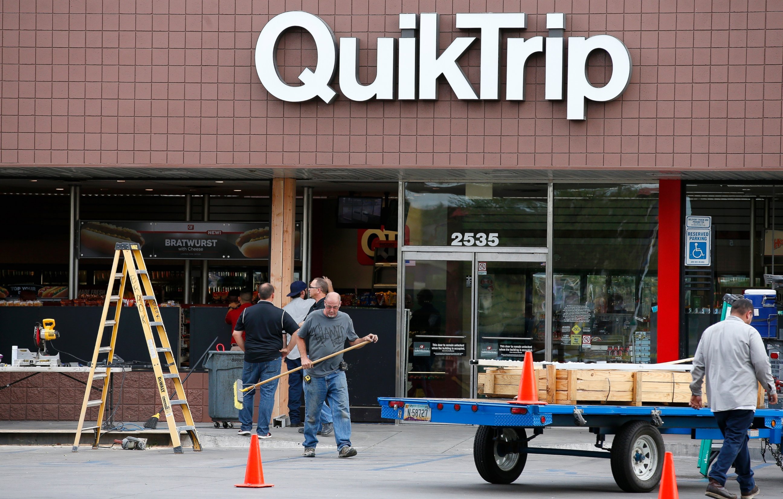 PHOTO: Construction workers continue cleaning up in front of a QuickTrip store hours after a driver plowed into two police officers, Sept. 13, 2016, in Phoenix. 
