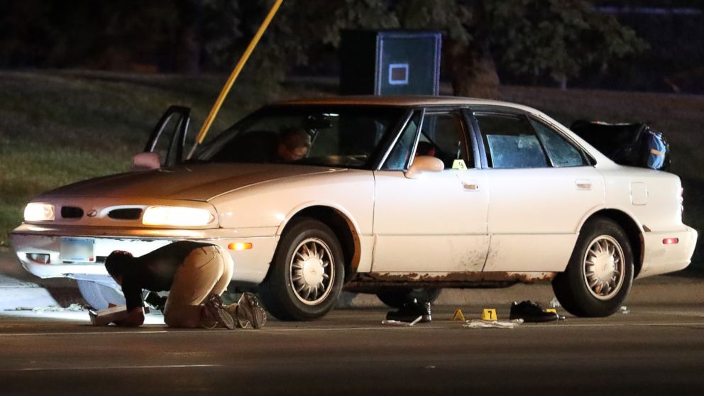 Investigators search a car at the scene of a police involved shooting, July 6, 2016, in Falcon Heights, Minn.