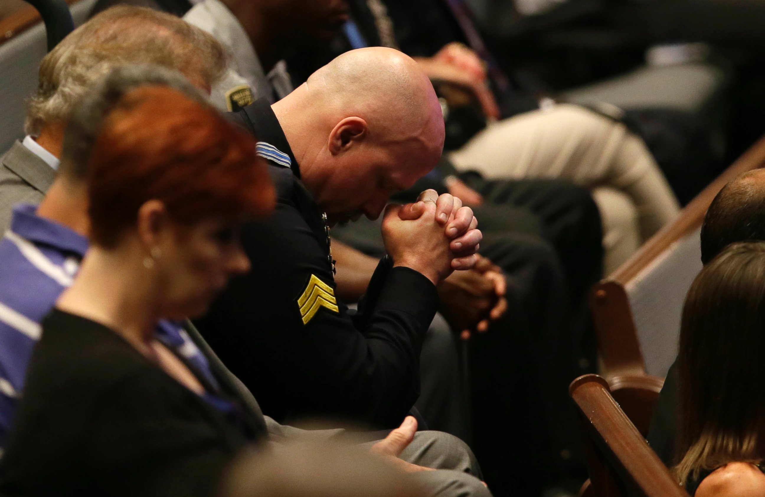 PHOTO: A police officer bows his head during the funeral for Dallas Police Sr. Cpl. Lorne Ahrens at Baptist Church in Plano, Texas, July 13, 2016.   