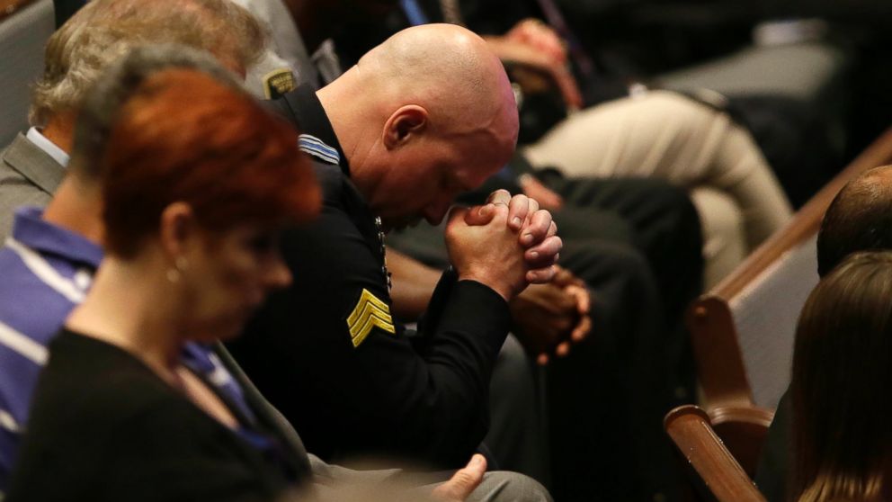 PHOTO: A police officer bows his head during the funeral for Dallas Police Sr. Cpl. Lorne Ahrens at Baptist Church in Plano, Texas, July 13, 2016.