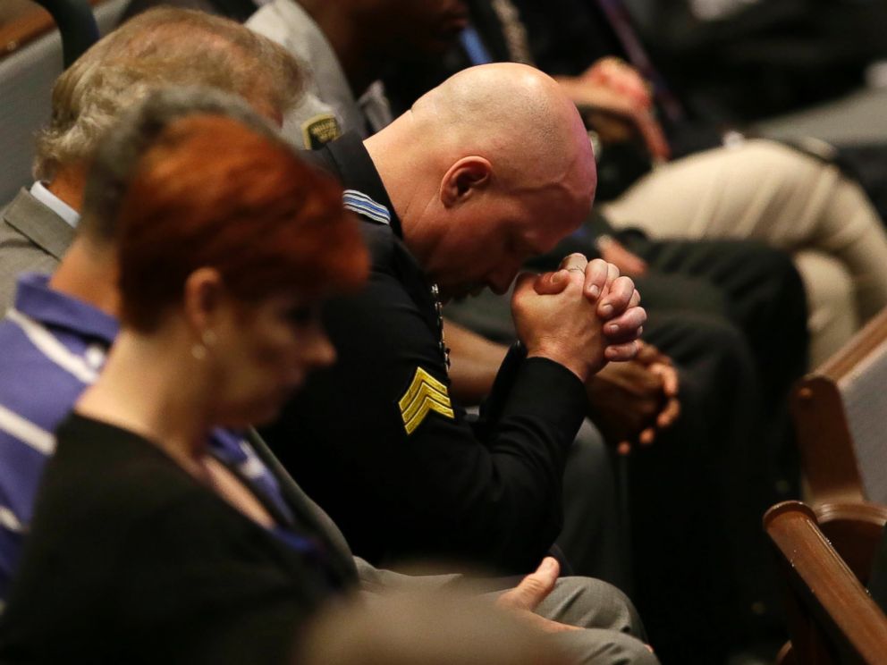 PHOTO: A police officer bows his head during the funeral for Dallas Police Sr. Cpl. Lorne Ahrens at Baptist Church in Plano, Texas, July 13, 2016.