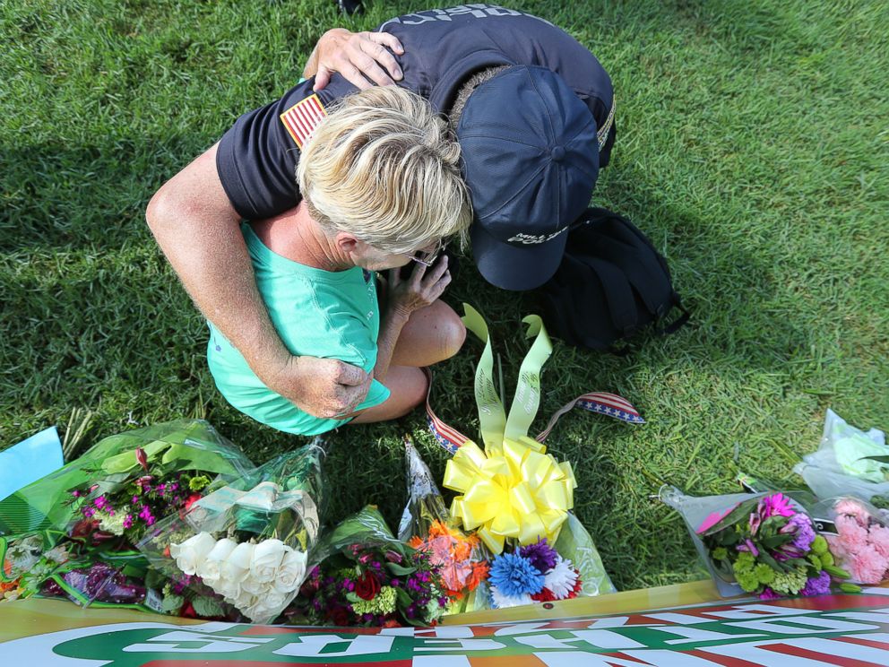 PHOTO: Millville, New Jersey Police Chaplain Bob Ossler prays and weeps with a local resident as she places flowers on a memorial at the B-Quik gas station, July 18, 2016, in Baton Rouge, Louisiana. 
