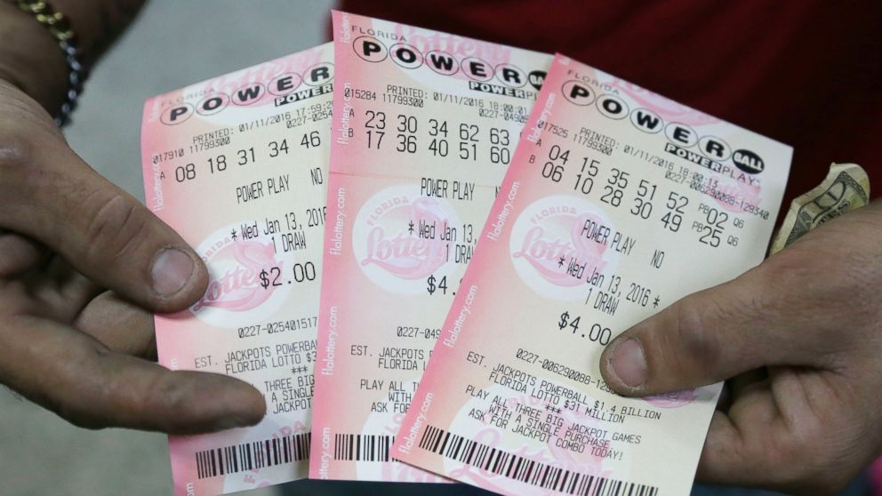 A customer shows his purchased Powerball tickets at a grocery store in Hialeah, Fla., Jan. 11, 2016.