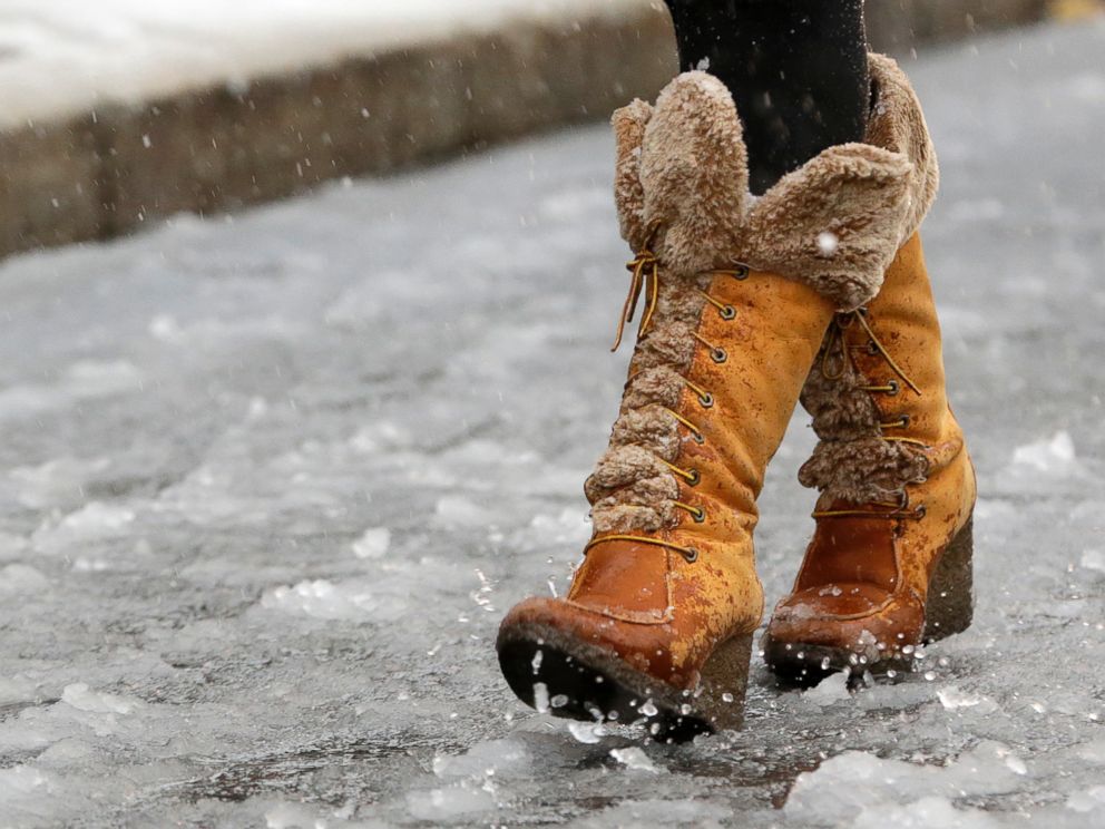 PHOTO: A woman walks over a road covered in slush, Nov. 26, 2014, in Newark, N.J.