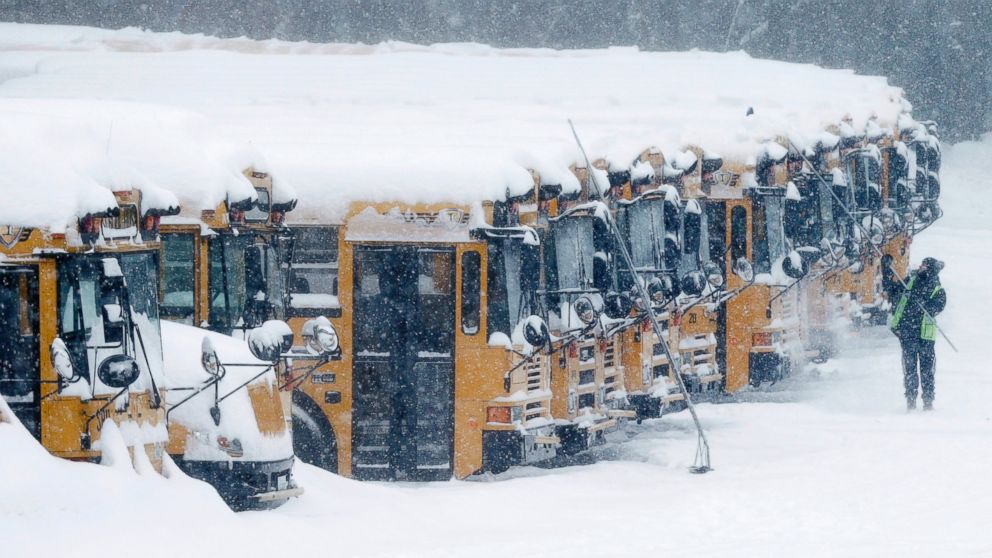 PHOTO: A driver cleans snow off school buses in Derry, N.H., Feb. 2, 2015.