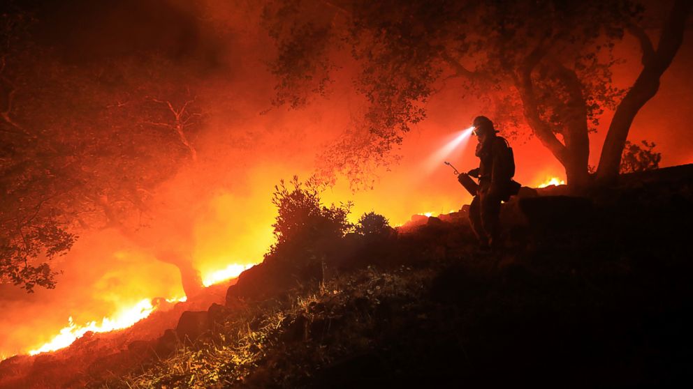 A San Diego Cal Fire firefighter monitors a flare up on the head of a wildfire (the Southern LNU Complex), off of High Road above the Sonoma Valley, Wednesday Oct. 11, 2017, in Sonoma, Calif.